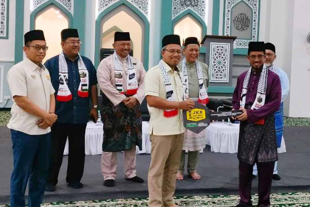 Aminuddin (lima dari kiri) ketika hadir pada majlis berkenaan turut menyaksikan penyerahan masjid secara simbolik pada Jumaat.