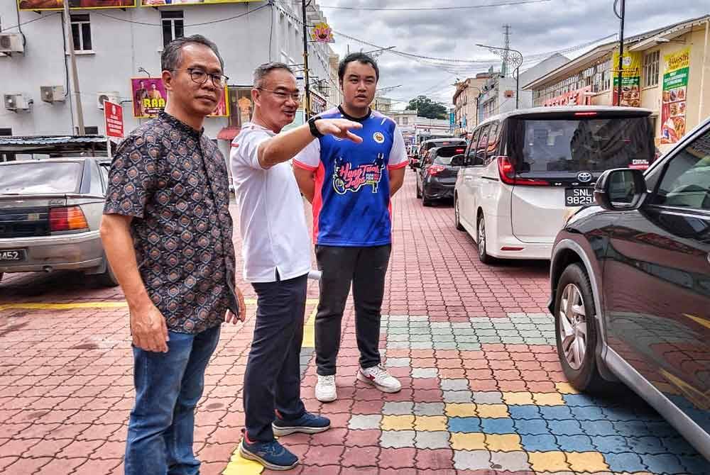 Poay Tiong (tengah) melihat kesesakan yang berlaku di Jalan Bendahara susulan penutupan jalan di bangunan merah Banda Hilir, sejak Jumaat.