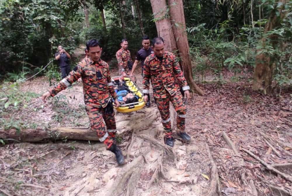 Pasukan bomba berjaya membawa turun salah seorang remaja yang terseliuh ketika mendaki Bukit 300, Teluk Batik pada Sabtu. - Foto ihsan Bomba Perak