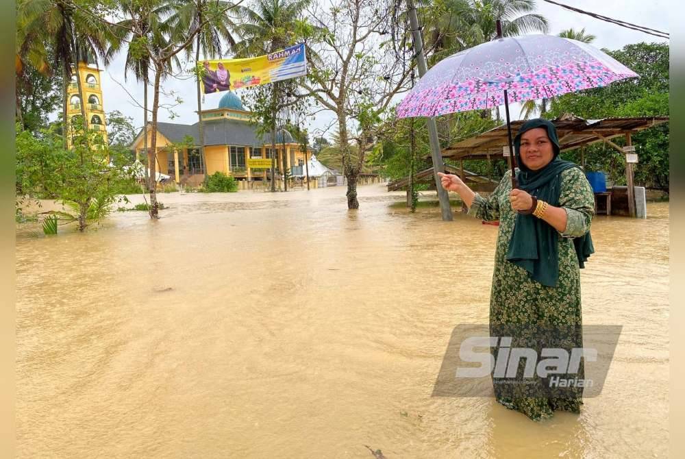 Sarifah Radiatul menunjukkan laluan ke rumahnya yang telah dinaiki air di Bukit Tandak, Rantau Panjang.