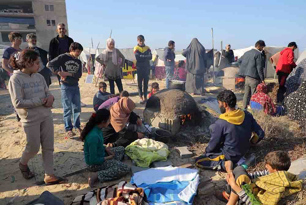 Penduduk Palestin menyediakan makanan di pusat perlindungan sementara di bandar Rafah di selatan Semenanjung Gaza. Foto Xinhua