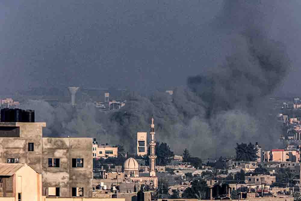 Asap menjulang ke langit di Khan Yunis semasa pengeboman dahsyat Israel dari Rafah di selatan Genting Gaza. - AFP