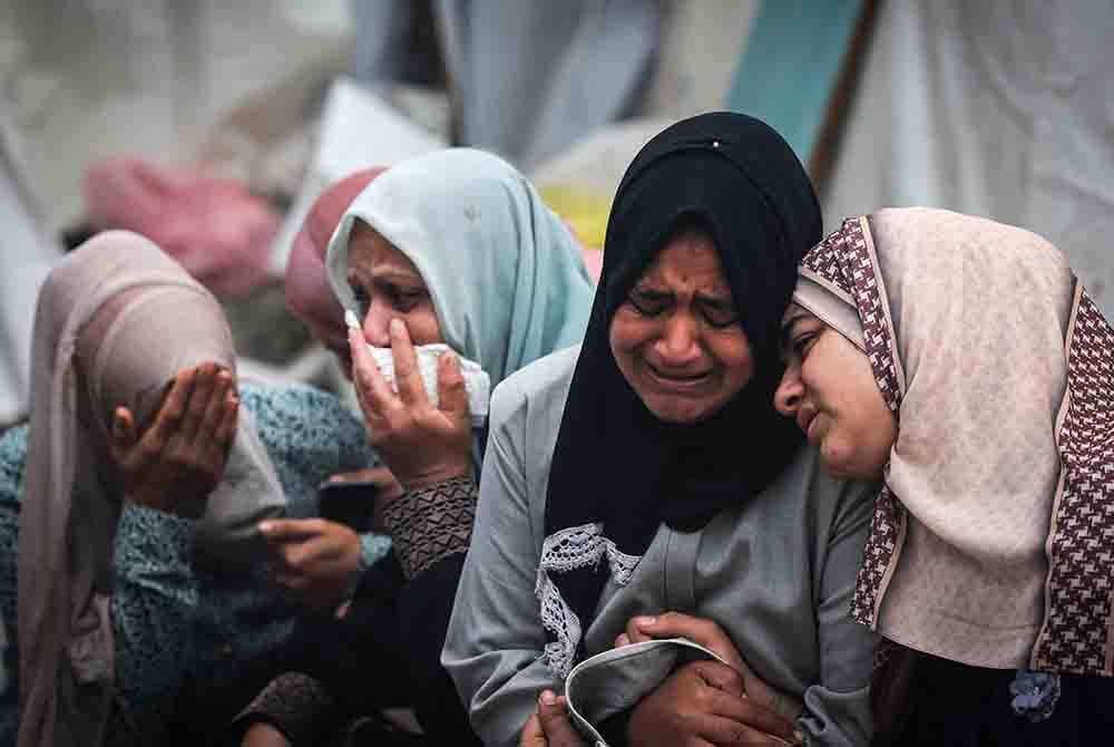 Penduduk Palestin di kem Al-Maghazi mengalirkan air mata selepas menghadiri pengebumian saudara mereka terkorban dalam serangan tentera zionis
di Hospital Al-Aqsa - AFP