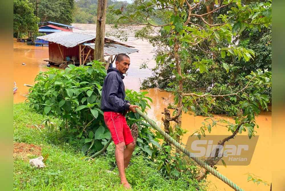 Rohaimin menggunakan tali kapal bagi memastikan sangkar ikan tidak dihanyutkan arus deras.