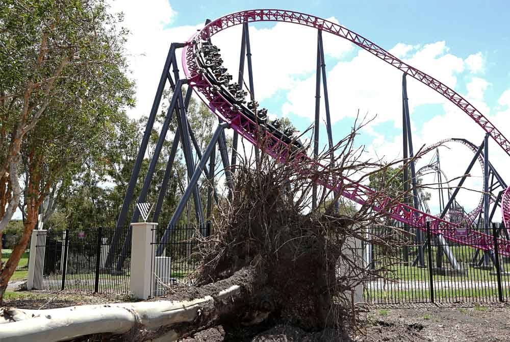 Orang ramai menaiki roller coaster berhampiran pokok tumbang selepas ribut di Helensvale di Gold Coast, Queensland, Australia pada Rabu. - Foto EPA