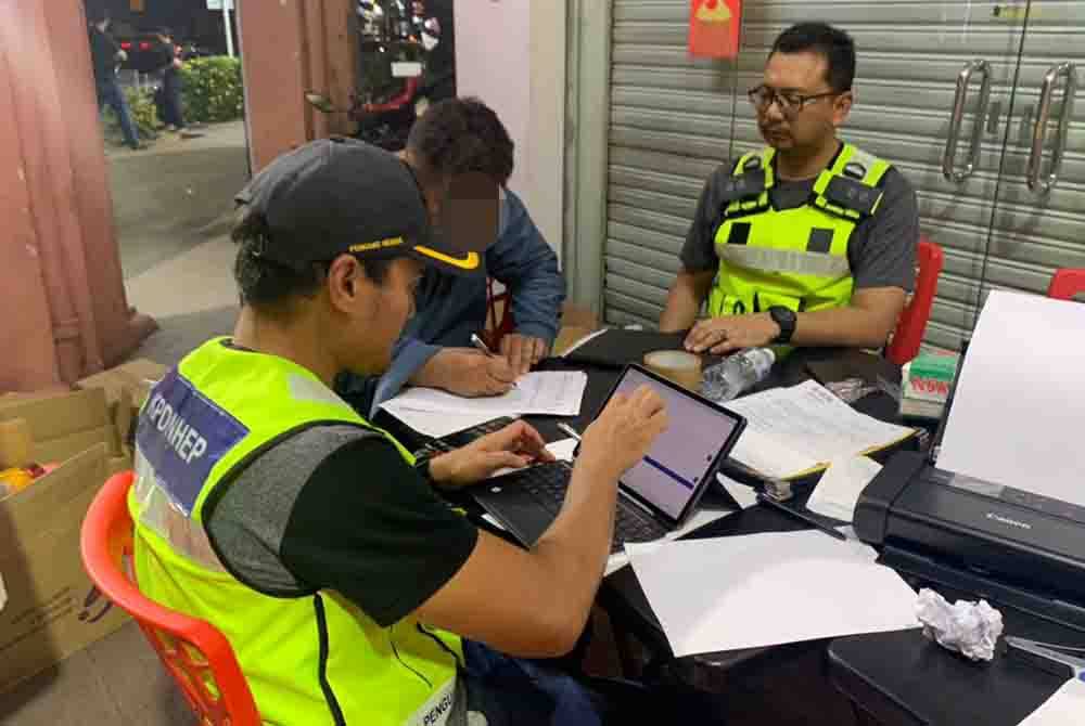 Seorang pemilik restoran berkonsepkan Asia Selatan mengemukakan dokumen kepada pegawai KPDN Kuala Lumpur semasa serbuan dijalankan baru-baru ini.