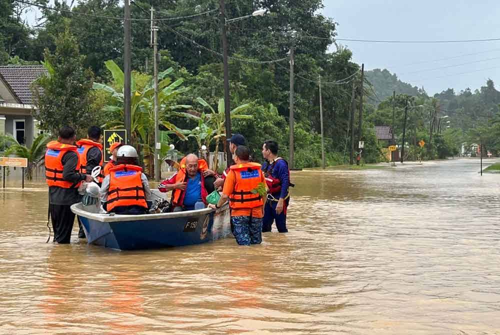 Anggota penyelamat membantu memindahkan penduduk yang terjejas banjir. - Foto Angkatan Pertahanan Awam Malaysia (APM)