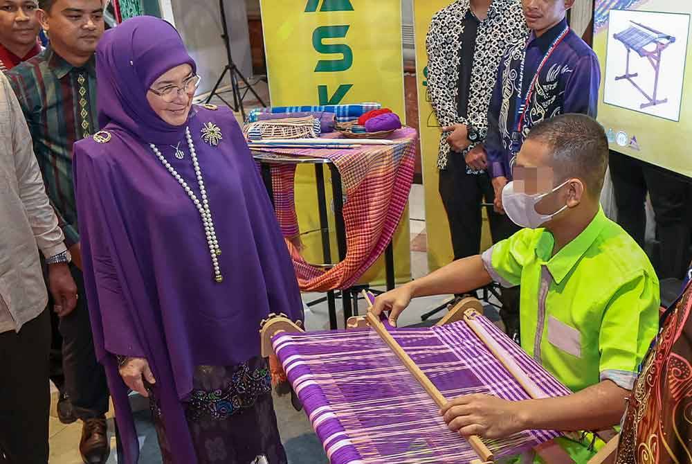 Tunku Azizah berkenan melihat penghuni penjara menenun songket semasa majlis Malam Simfoni Kasih 2023 Jabatan Penjara Malaysia di sini malam ini. - Foto Bernama