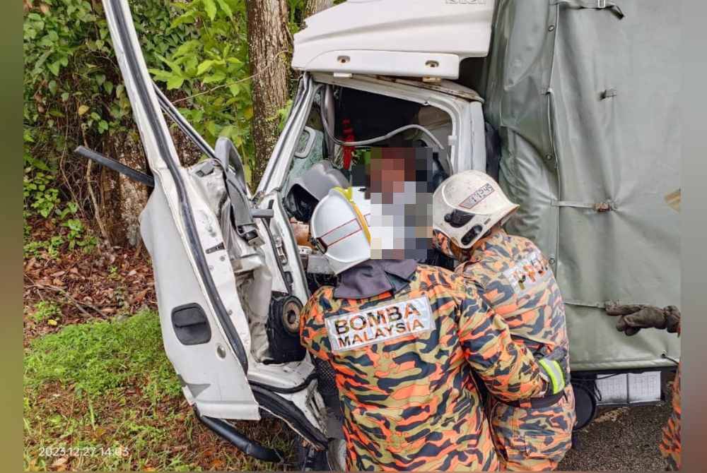 Anggota bomba mengeluarkan mangsa yang tersepit di dalam lori. Foto BBP Kluang