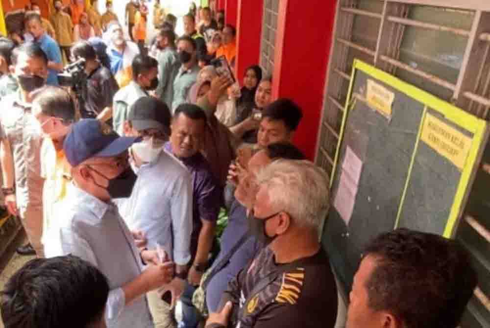 Anwar (kiri) beramah mesra dengan mangsa banjir yang ditempatkan di PPS SMK Agama Lati, Pasir Mas pada Khamis.