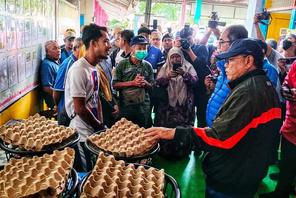 Wan Rosdy(Kanan) bersama bantuan yang diserahkan kepada mangsa banjir