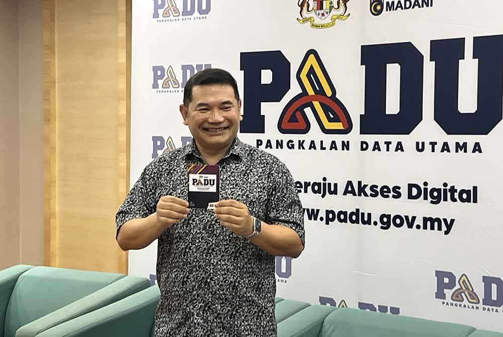 Rafizi menunjukkan kad NFC daripada Touch n Go ketika sidang akhbar selepas sesi penerangan kepada Ketua Pengarang Media Massa di Putrajaya pada Jumaat.