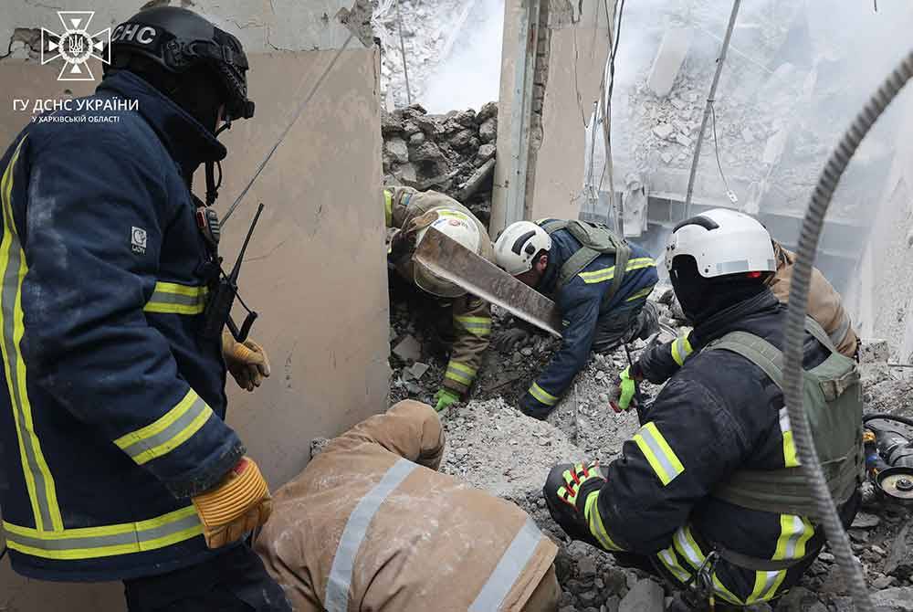 Anggota bomba Ukraine bertugas di lokasi berlakunya serangan roket oleh Rusia di Kharkiv pada Jumaat. - Foto AFP