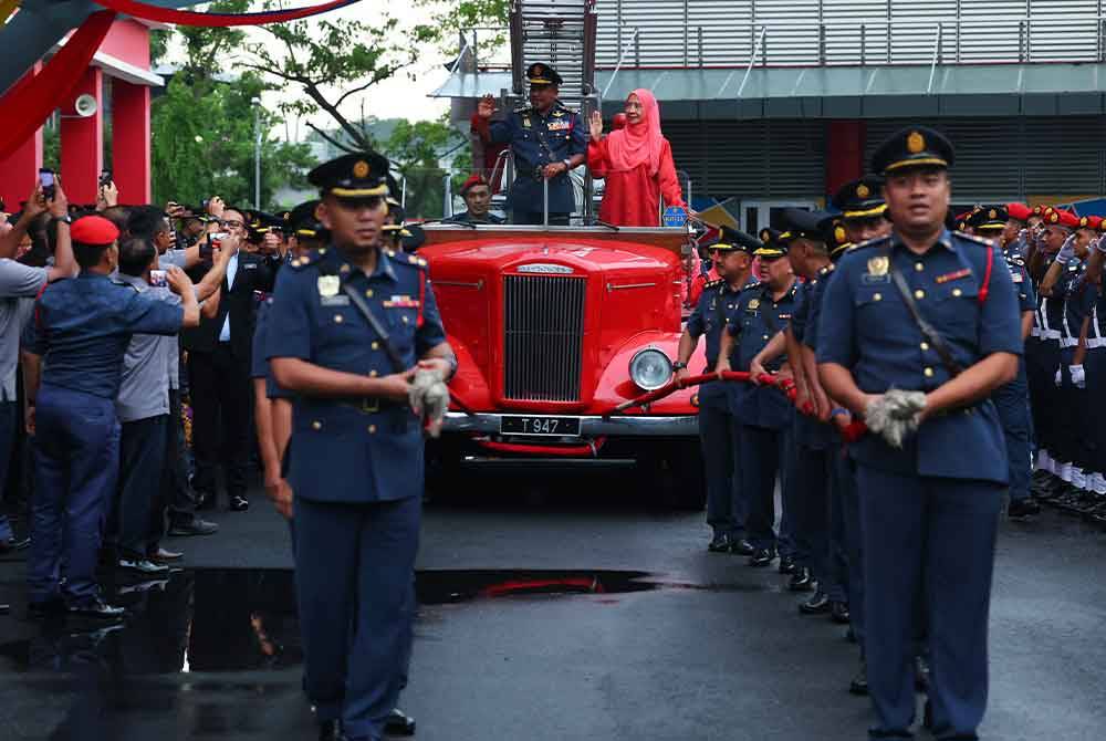 Abdul Wahab dan isteri, Datin Seri Nor Latifah Jaafar menaiki kenderaan istiadat yang ditarik oleh pegawai-pegawai kanan JBPM sebagai simbolik menamatkan tugas pada Majlis Perbarisan Penghargaan Ketua Pengarah JBPM di Ibu Pejabat JBPM Putrajaya hari ini. - Foto Bernama