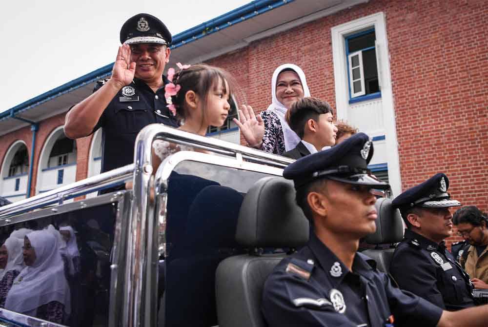 Aidi (kiri) bersama isteri, Raja Asaudat (dua, kiri) melambaikan tangan ketika menaiki kenderaan khas pada Majlis Paluan Berundur Pengarah JPJKK Bukit Aman di Pulapol Kuala Lumpur. - Foto Bernama