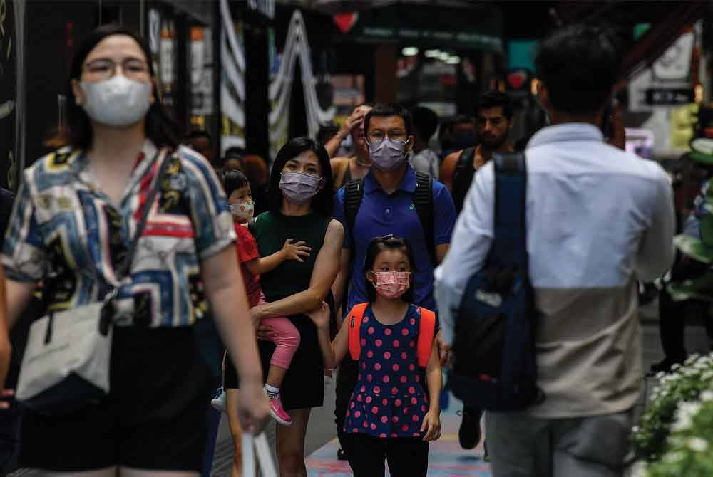 Segelintir orang ramai mula memakai pelitup muka ketika berada di kawasan awam berikutan kes Covid-19 kembali meningkat semasa tinjauan di Bukit Bintang pada Jumaat. - Foto Bernama