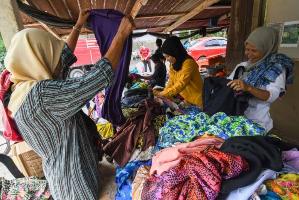 
Penduduk kampung yang menjadi mangsa banjir rambang mata memilih pakaian terpakai yang disumbangkan oleh NGO ketika tinjauan di Kedai Kopi Tok Doh, Kampung Serongga, pada Ahad. Foto Bernama