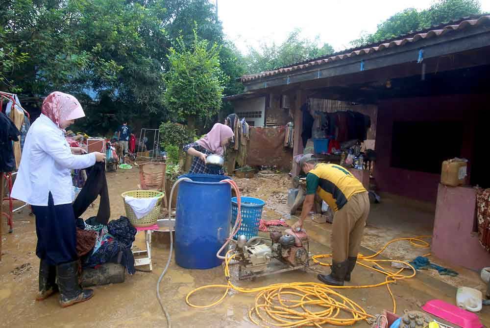 Penduduk membersihkan kesan lumpur di rumah mereka pada Ahad selepas banjir surut di Kampung Kumung, Chanae di Narathiwat, Selatan Thailand. - Foto Bernama