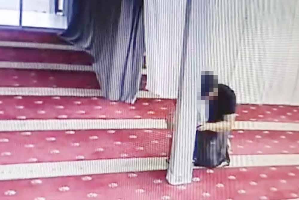 Tangkap layar video yang tular memaparkan seorang lelaki dipercayai sedang mencuri wang tabung sebuah surau di Ulu Tiram, Johor Bahru pada Ahad