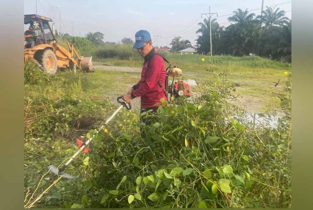 Ahmad Yunus membersihkan semak selepas terima aduan di Kampung Medan di Kuala Langat.