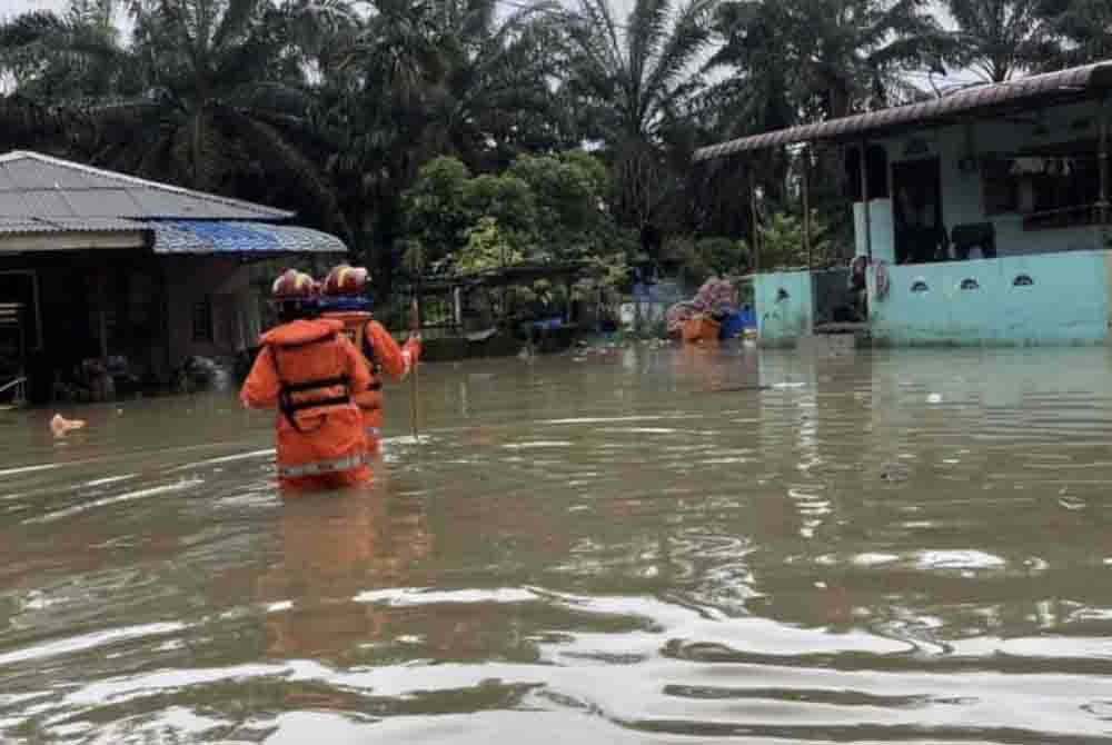 Anggota Pertahanan Awam Malaysia meninjau keadaan di sebuah kampung di Mersing yang dinaiki air sejak Khamis.