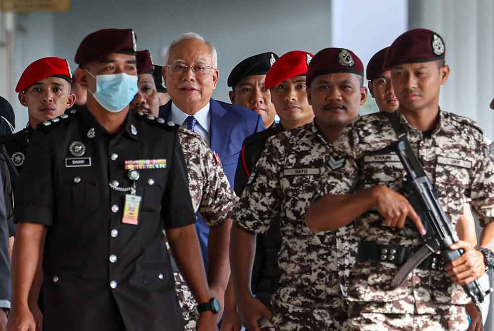 Najib diiringi pegawai penjara ketika hadir bagi prosiding sambung bicara kes penyelewengan dana 1MDB di Mahkamah Tinggi di Kuala Lumpur pada Jumaat. - Foto Bernama