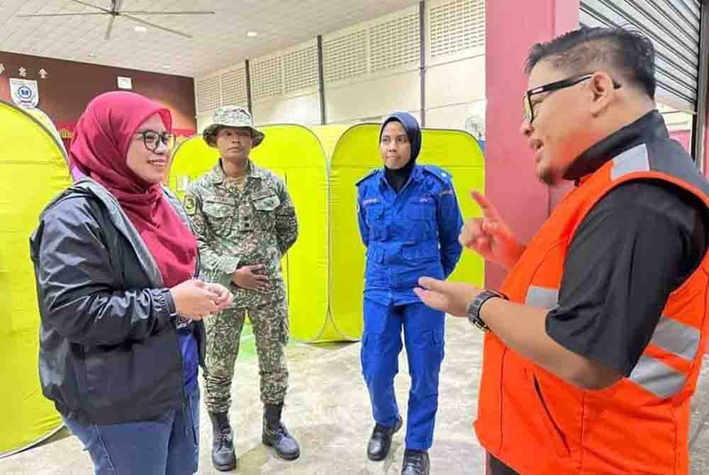 Norlizah (kiri) ketika melawat pusat pemindahan sementara di sekitar Kota Tinggi.