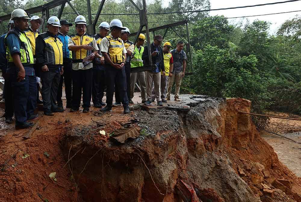 Alexander Nanta Linggi meninjau pemasangan jambatan Panel Keluli Bermodular (Bailey Bridge) di kawasan kejadian jalan mendap di laluan FT66 Seksyen 73.850 Jalan Dabong-Jeli pada Sabtu. Foto Bernama