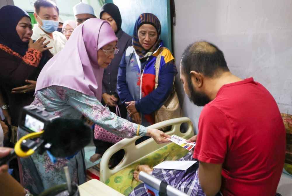 Isteri Perdana Menteri yang juga Ahli Parlimen Bandar Tun Razak Datuk Seri Dr Wan Azizah Wan Ismail melawat dan menyampaikan sumbangan kepada Nor Aliff Mohd Nor, 37, yang menghidap penyakit kronik pada Program Penyerahan Bantuan Khas di Perumahan Awam Sri Johor pada Ahad. Foto Bernama