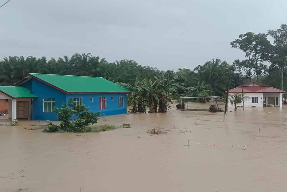 Sebahagian rumah penduduk di Kampung Sri Jaya, Kota Tinggi yang mula ditenggelami air sejak pagi Ahad.