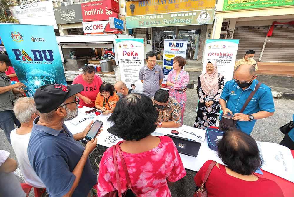 Orang ramai mengambil peluang mendaftar PADU di kaunter disediakan di Pasar Malam Taman Galena