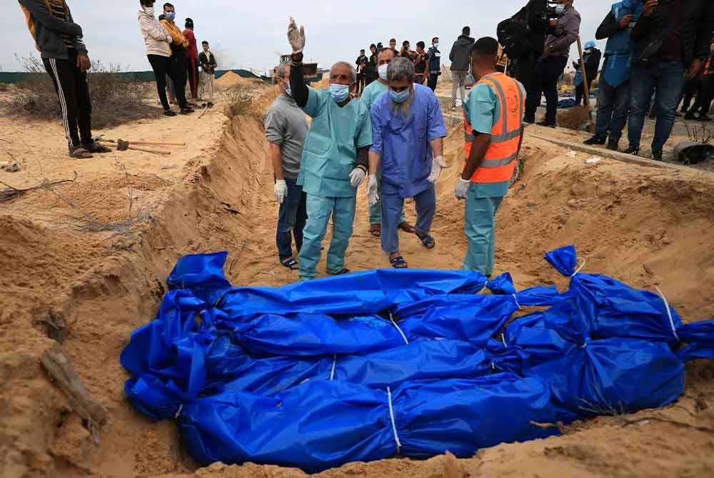 Penduduk Palestin mengebumikan semula mayat di tanah perkuburan Khan Yunis, Genting Gaza. - AFP