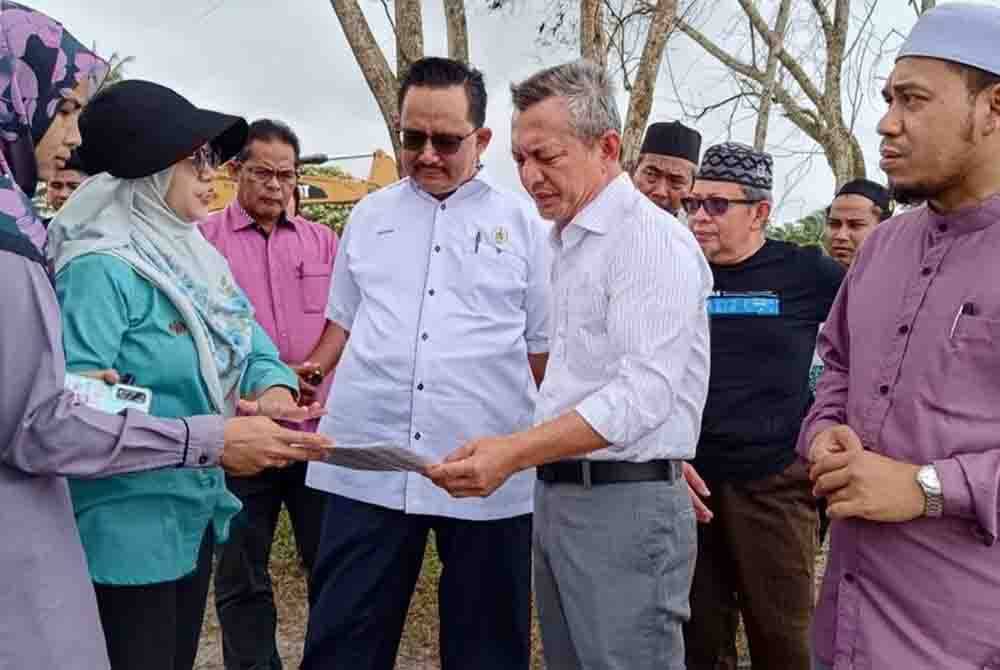 Razali (dua dari kanan) bersama Ahmad Ridzwan (tengah) dan Mohd Shafizi (kanan) ketika meninjau keadaan perigi lama di Kampung Mengabang Kapal, Batu Rakit di Kuala Nerus.