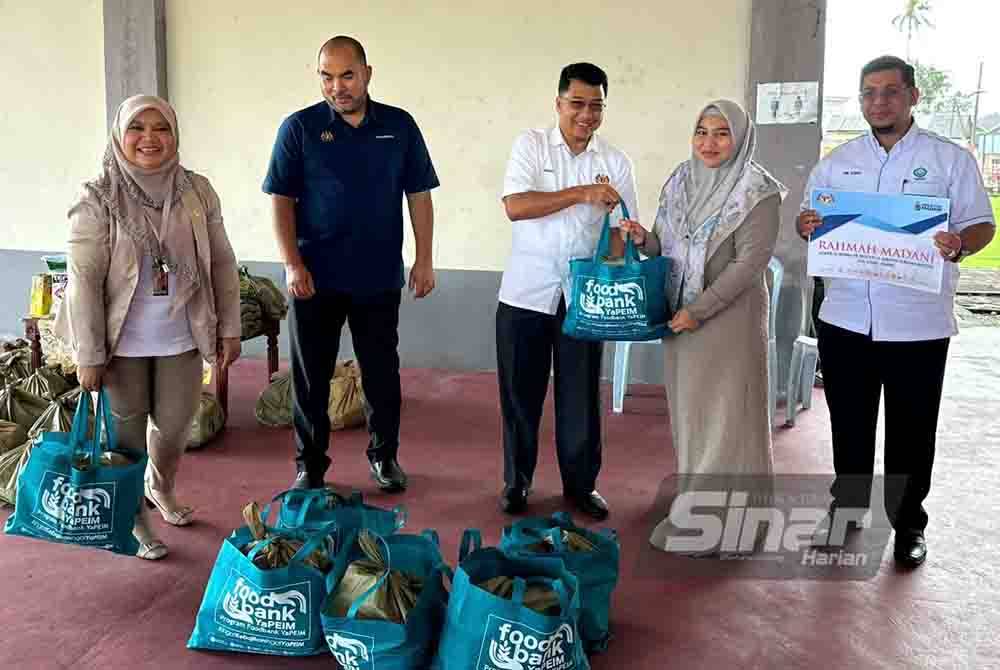 Muhd Nor Aswadi (tengah) menyampaikan pek makanan kepada wartawan di Kota Bharu.