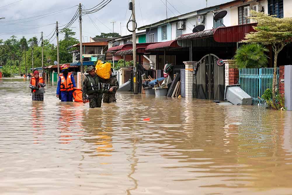 Anggota Angkatan Pertahanan Awam Kota Tinggi dan Angkatan Tentera Malaysia membantu menyelamatkan mangsa banjir yang terperangkap di Taman Kemang, Kota Tinggi, Johor ketika tinjauan hari ini. Foto Bernama