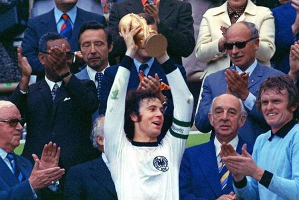 Beckenbauer (tengah) ketika menjulang Piala Dunia untuk pasukan Jerman Barat pada tahun 1974. - Foto AP