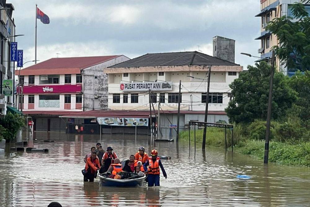 Anggota bomba menyelamatkan mangsa banjir yang terperangkap dalam rumah mereka di kampung dan taman sekitar bandar Kota Tinggi pada Isnin.