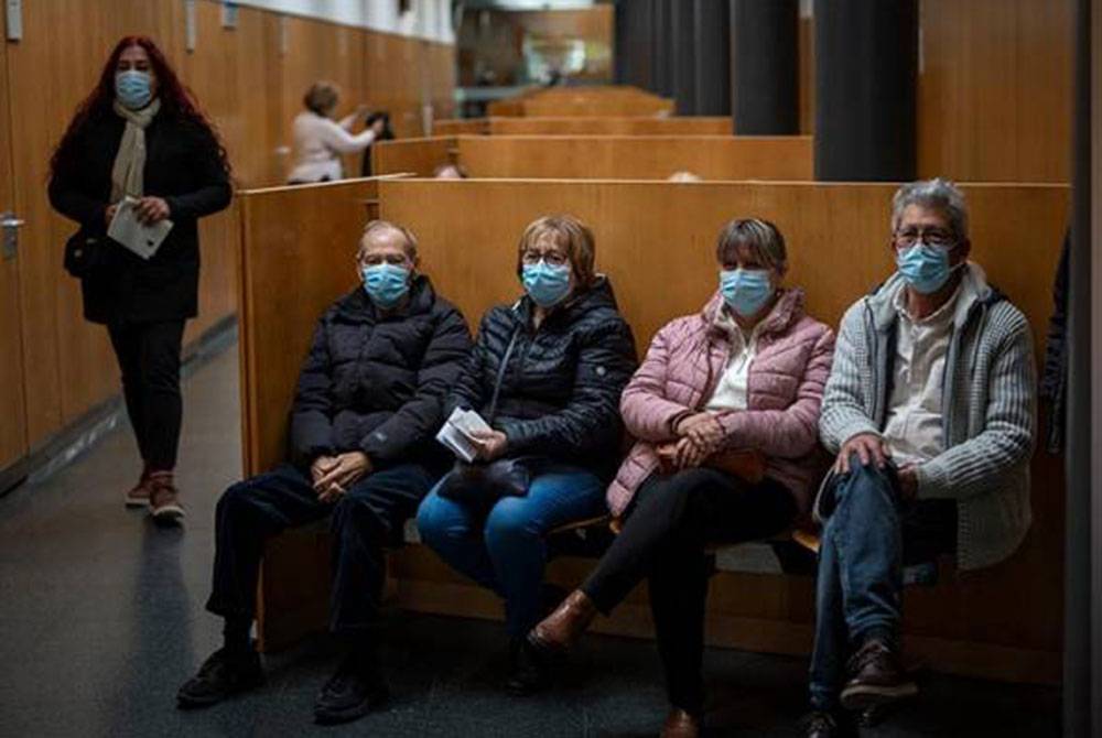 Orang ramai memakai topeng pelitup muka ketika menunggu giliran berjumpa dengan doktor di sebuah hospital Barcelona. - Foto AP