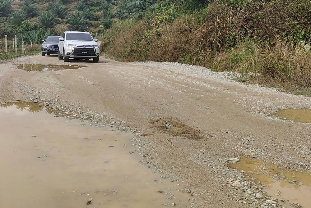 Keadaan jalan berlubang, berlopak, berlumpur dan licin yang terpaksa dilalui penduduk tiga ladang di sini setiap hari.