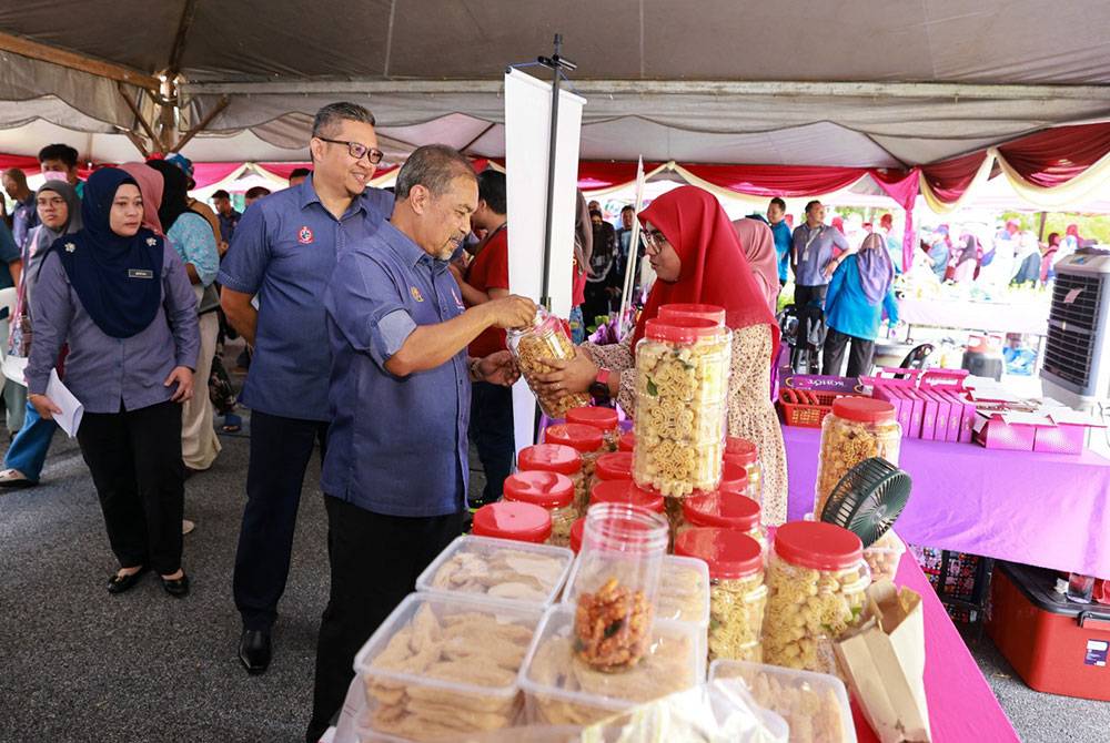 Jamil Khir (dua dari kiri) menyantuni usahawan KEDA semasa pelancaran jualan kasih KEDA di Kompleks KEDA pada Selasa.