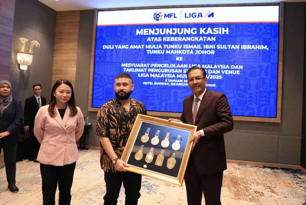 Tunku Ismail (tengah) menerima cenderamata daripada Ab Ghani sambil diperhatikan Yseow Suan selepas Mesyuarat Pengelolaan Liga Malaysia dan Taklimat Pengurusan Stadium dan Venue Liga Malaysia Musim 2024/2025 di sebuah hotel di Iskandar Puteri pada Selasa