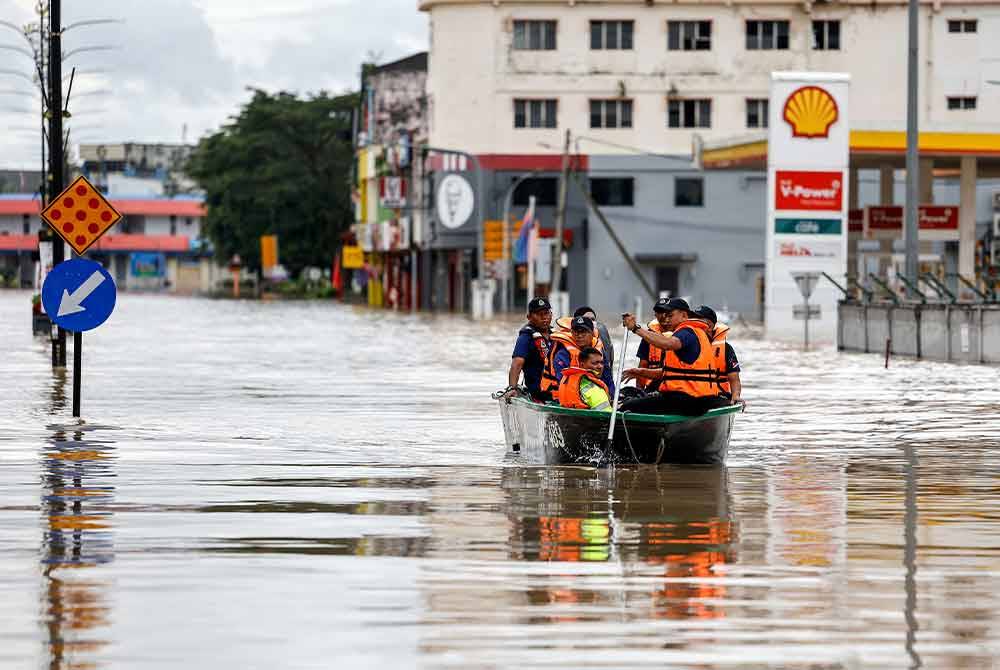 Anggota polis menggunakan bot penyelamat bagi membawa mangsa-mangsa yang terperangkap akibat bencana banjir, ketika tinjauan di Pusat Bandar Kota Tinggi, pada Selasa. Foto Bernama