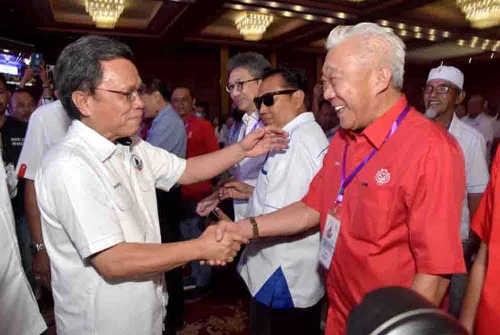 Bung Moktar (kanan) bersalam dengan Mohd Shafie ketika hadir pada Perhimpunan Agung Tahunan Parti Warisan yang diadakan di Dewan Hakka Likas, Kota Kinabalu baru-baru ini.