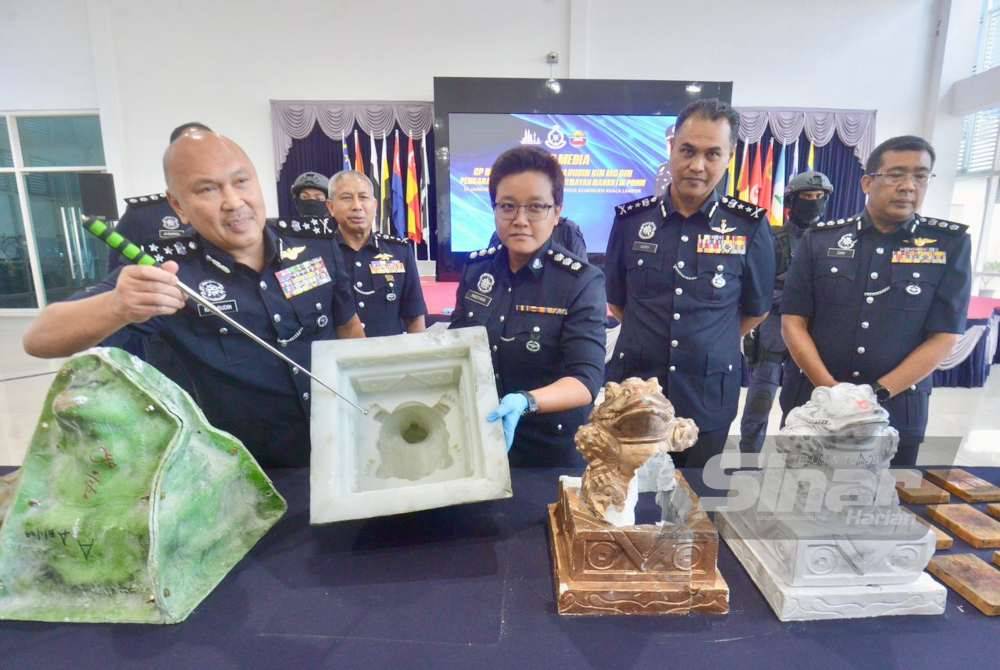 Kamarudin menunjukkan acuan patung seni yang dirampas dalam serbuan di sebuah kondominium di ibu kota pada sidang media di Ibu Pejabat Polis Kontinjen Kuala Lumpur pada Rabu.