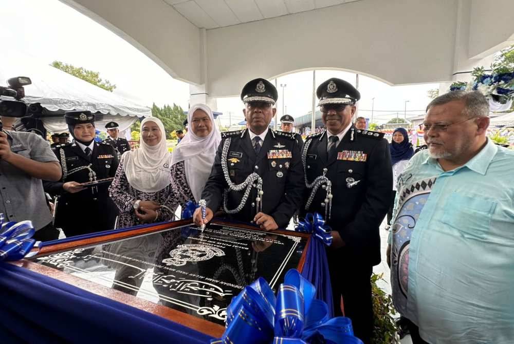 Kamarul Zaman (tiga dari kanan) menurunkan tandatangan pada plak perasmian Balai Polis Sri Gading, Batu Pahat pada Rabu.