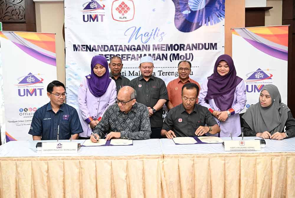 Mazlan (duduk, dua dari kiri) bersama Mohd Radzi (duduk, dua dari kanan) menandatangani MoU dalam bidang penyelidikan kelulut dan melon manis di Bangunan Canselori UMT. Foto UMT