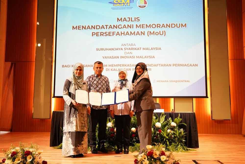 Nor Azimah (kiri) dan Sharmila (kanan) bertukar dokumen MoU pada Majlis menandatangani MoU membangunkan serta mempromosi STIE dalam negara.