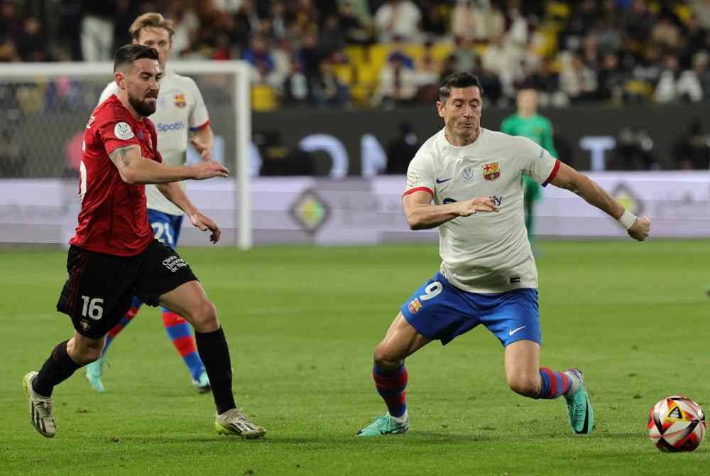 Penyerang Osasuna, Moi Gomez dan penyerang Barcelona, Robert Lewandowski cuba merebut bola dalam aksi separuh akhir Piala Super Sepanyol. Foto AFP