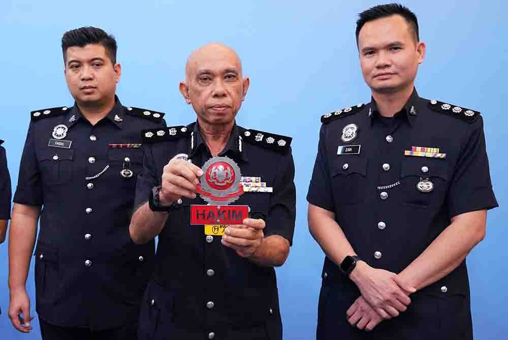 Ahmad Sukarno (tengah) menunjukkan lambang hakim yang dicabut daripada sebuah kenderaan rasmi milik seorang Hakim Mahkamah Persekutuan oleh dua orang pelajar dalam satu kejadian baru-baru ini. FOTO: SINAR HARIAN/HALIM ABDUL WAHID