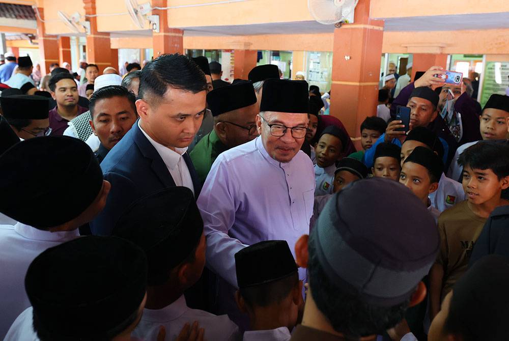 Anwar tengah) bersalaman dengan para jemaah selepas menunaikan solat Jumaat di Masjid Al-Hijrah Persiaran Desa Pinggiran Putra hari ini. Foto: Bernama